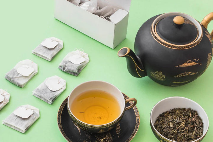 Cup of tea, teapot, & tea sachets | Green tea benefits for skin