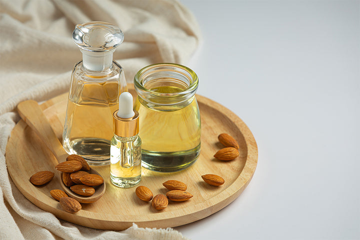 3 container of almond oil and almonds kept in a plate | almond oil benefits