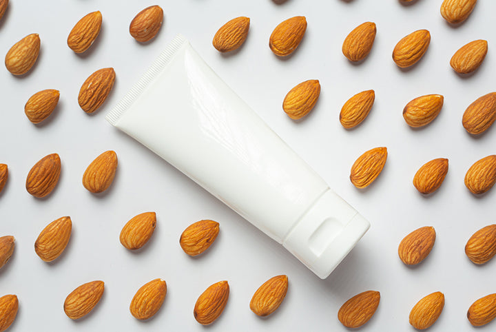 Moisturizer bottle and almonds | almond benefits for skin