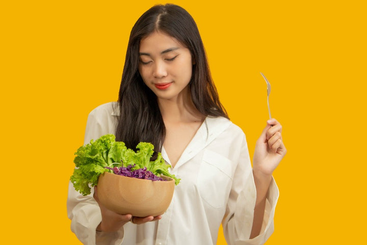 a woman holding a bowl of salad