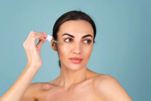 a woman applying facial oil on her face