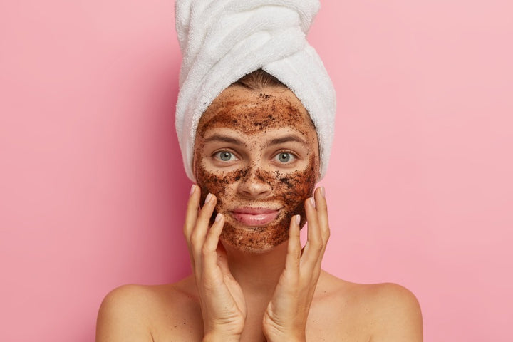 a woman has applied coffee scrub on her face to exfoliate her skin | DIY Body Scrubs for Proper Exfoliation