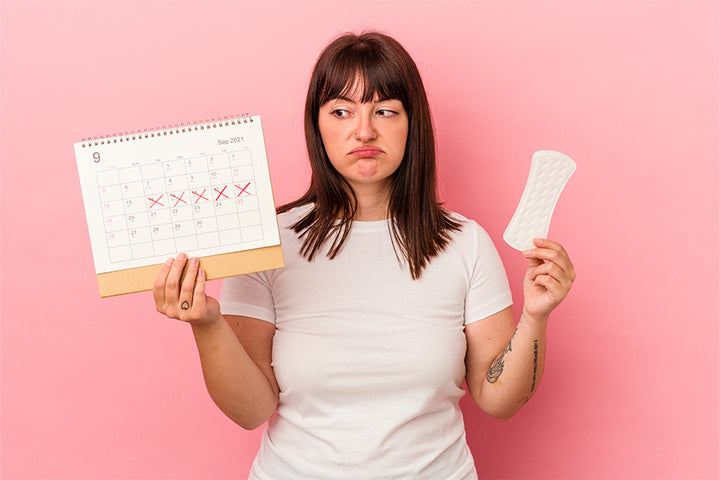 A woman holding calender and sanitary pad | Period Myths
