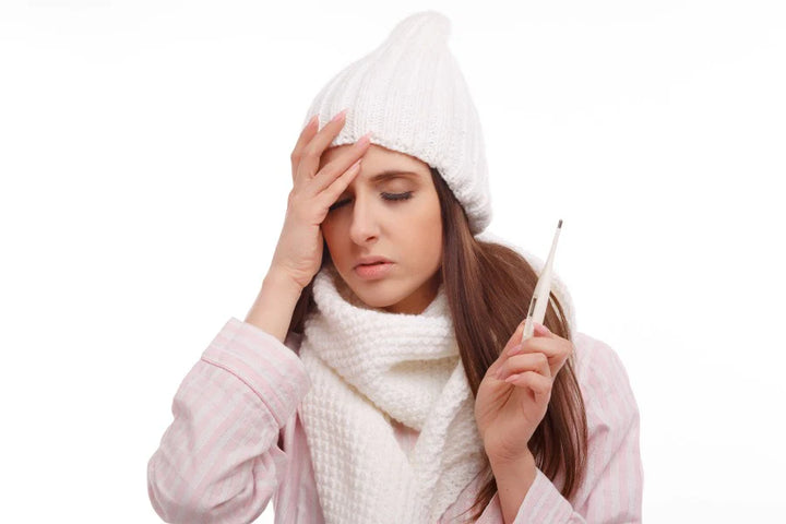 A woman holding a thermometer | What to Eat in Fever