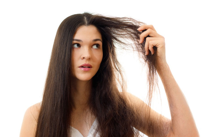 a woman holding her frizzy hair