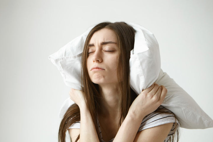 a woman has put pillow around her neck | How to Deal With Sleep Difficulties in Your 30s