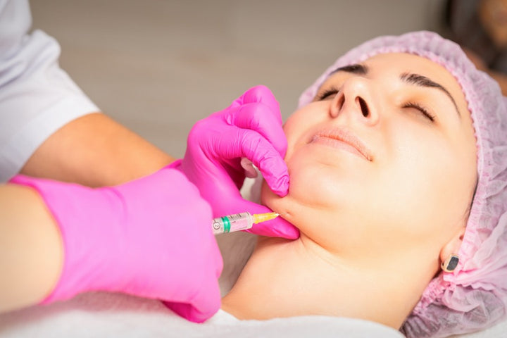 a woman getting injection to treat sagging jawline