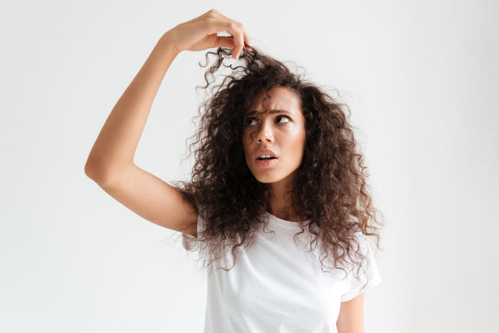 a woman with sweaty scalp is watching her hair | How to Stop Scalp Sweating