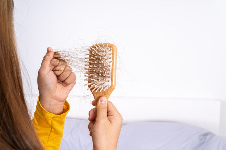 a woman holding a comb filled with hair