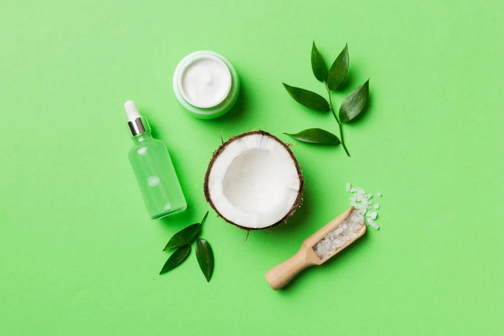 Two half coconut, bottle, and leaves | benefits of applying coconut oil on face overnight