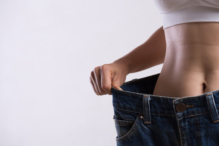 a woman suffering from unexplained weight loss is wearing a loose jeans | Sudden Weight Loss: Possible Causes & Remedies