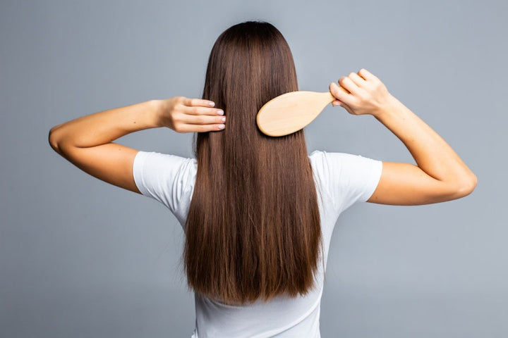 a woman with straight her is combing her hair