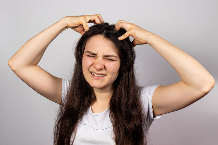 a woman scratching her scalp