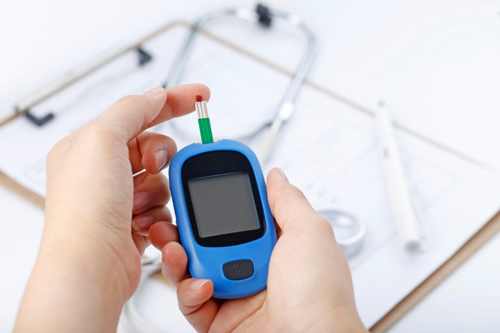 a woman checking her blood sugar level using a glucometer