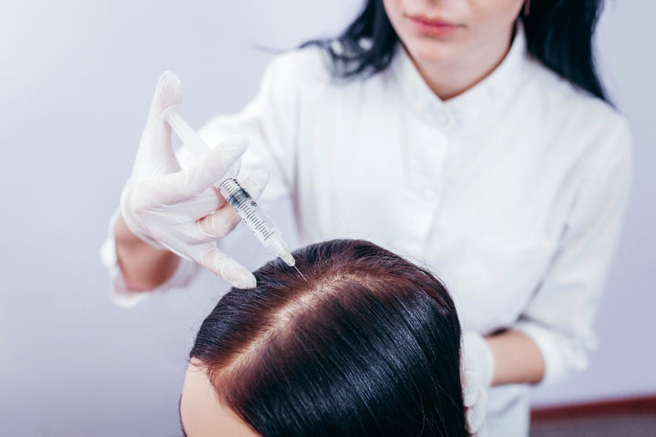 a doctor using injection on a woman's scalp