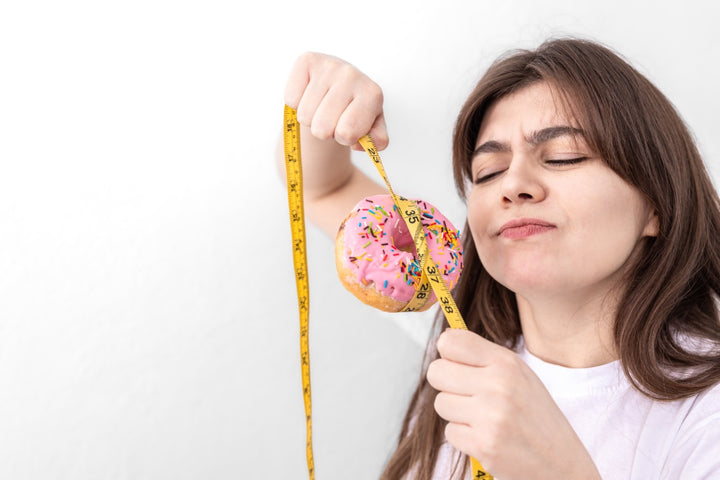 a woman holding a donut and measuring it with a measuring tape