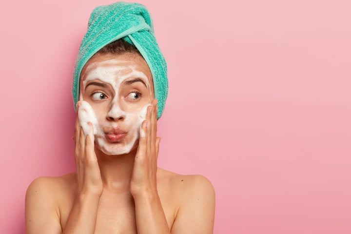 a woman is using foam face wash