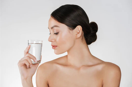 a girl drinking water to balance her skin's pH