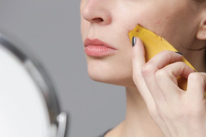 a girl applying banana peel on her face